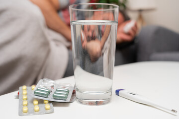 Close-up of medicine water and thermometer as flu concept