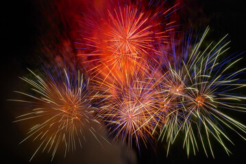 Red colorful fireworks on the black sky background. Holiday celebration