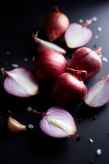 Red onion on black background Whole and sliced onions, salt, garlic and spices. Flat lay, copy space