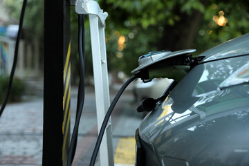 Charging modern electric car from station outdoors