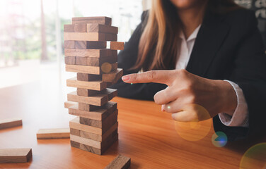 The business man's hand is planning a business strategy, the businessman plays the wooden block tower,