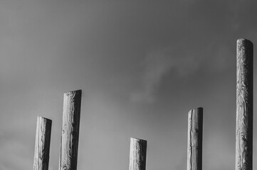 Abstract black and white pillars against cloudy sky