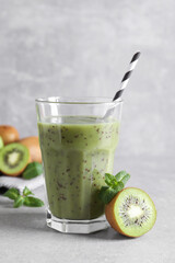 Delicious kiwi smoothie and fresh fruits on light table