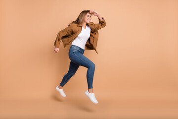 Full size profile side photo of blonde haired woman wear jeans jump run look empty space isolated...