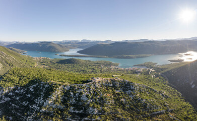 Obraz premium Aerial drone shot of City Wall of Ston over hill to Mali Ston in Croatia summer morning sunrise