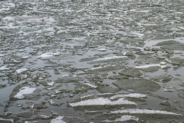 Water with floating ice floes. Spring background with melting ice and melting snow.