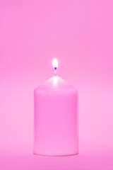 Coloured candle against a pink background