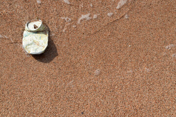 Fototapeta na wymiar Old Tin Can of Drink on Wet Red Sand of Red Sea