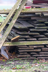 A pile of boards has been standing for a long time. Improperly stored timber.