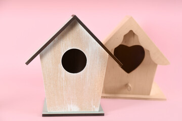 Obraz na płótnie Canvas Beautiful wooden bird houses on pink background