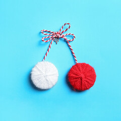 Traditional martisor on light blue background, top view. Beginning of spring celebration