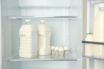 Gallons of milk near eggs in refrigerator, closeup