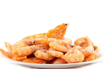 Pile of frozen shrimp on a white plate over a white background.