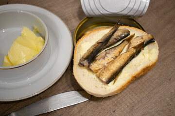 Sprats on bread with tin can on wooden background. Sprats made. in latvia.