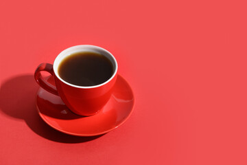 Red cup of coffee on monochrome red background. Copy space. Close up.