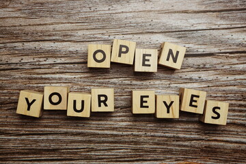 Open your eyes alphabet letters on wooden background