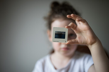 Young girl child looking at vintage retro slide