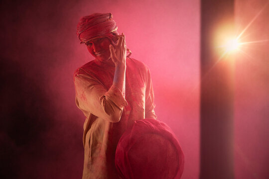 A YOUNG MAN COVERED IN HOLI COLOURS STANDING AND LOOKING AT CAMERA - Powered by Adobe