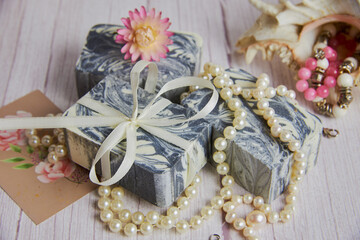 Fototapeta na wymiar Gray-white handmade soap made from natural ingredients is decorated with pearl beads.