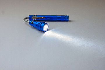 Blue metal LED flashlight isolated on the white background