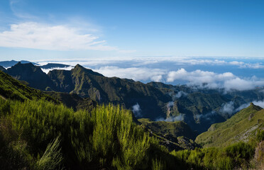 Above the clouds on a mountain trail. Colorful mist in valley. Trekking from Pico do Arieiro to Pico Ruivo, Madeira island, Portugal. 