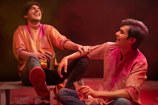 TWO HAPPY MEN SITTING TOGETHER AND DRINKING BHANG DURING HOLI	