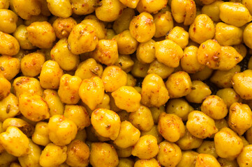 Cooking chickpeas with spices in a pan, close-up