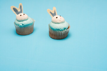 Easter muffins on light blue background. Rabbit cupcakes. Easter concept