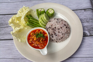 Nam phrik ong is a popular Thai food in Northern Thailand. Composition with rice, pork and fresh vegetables as cucumber, Chinese cabbage, cow pea, eggplant. 