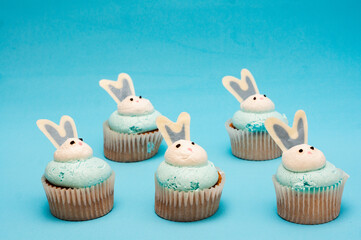 Bunch of cupcakes on blue background. Minimalistic composition. Easter concept