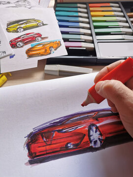 A man draws a new design project for a future car at home