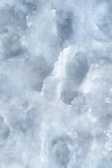 Shoe marks on the melted snow, thaw, slush. The surface of the melted snow on the road, top view