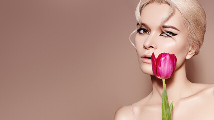 Beautiful sexy Blonde Woman with luxury Make-up. Girl with Spring Flowers Bouquet. Style for Womans Day or Valentines