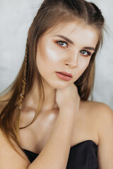 Professional portrait of a beautiful brunette model on a light background, portrait of a girl with make-up.