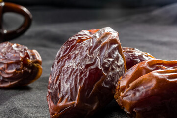 Big luxury dried date fruit on the dark surface, kurma ramadan kareem concept, close up.