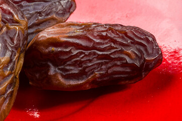 Big luxury dried date fruit in bowls on the bamboo mat, kurma ramadan kareem concept, close up.