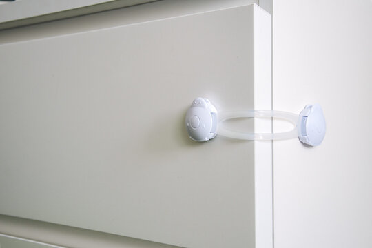 Children's plastic stopper on the chest of drawers. Children's lock for furniture boxes, refrigerator. Providing a safe space for children.