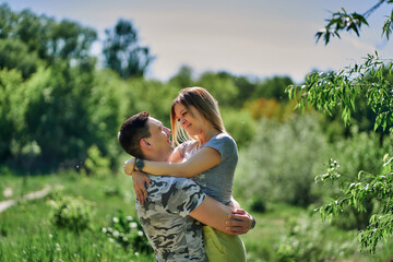 A loving romantic couple hugs in nature. The man lifted the woman into his arms. Close-up