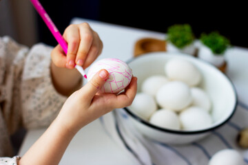 Little girl paints easter eggs. Easter concept. Preparing for Easter. Happy easter.