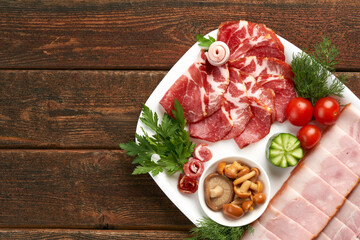 Traditional cuisine, raw ham, Italian Parma ham. Snack on a wooden table. Copy space