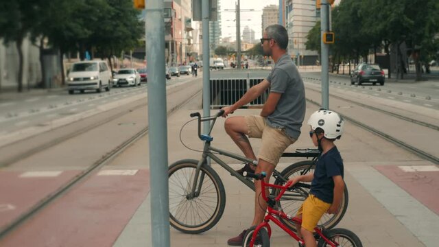Father and son on bike. Father and son riding a bike together in barcelona spain, dad and kid, happy family safety sport