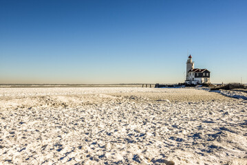 The lighthouse of Marken, 'het Paard van Marken' in winter and the frozen Markermeer, Holland. © Bert
