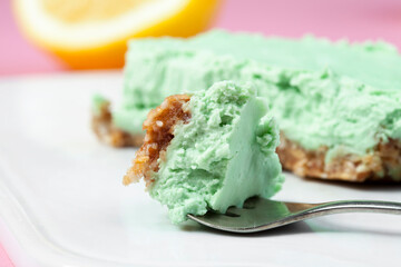 
Raw vegan cheesecake with lime and cashew nuts. Vegan raw cheesecake on a pink background without flour and sugar