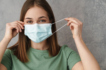 Pleased caucasian girl posing in protective mask