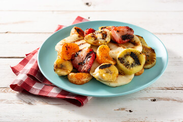 GRILLED FRUIT on a blue plate and white wooden background