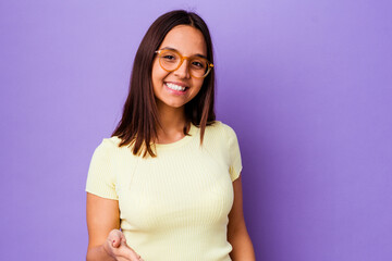 Young mixed race woman isolated stretching hand at camera in greeting gesture.