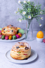 Craffin (Cruffin) with raisins, nuts and candied fruits. Easter Bread Kulich and painted eggs. Easter Holiday. Close-up.