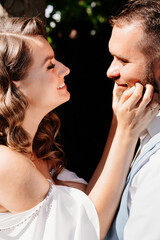 close up. Happy and beautiful bride and groom gently cuddle in park. touches.