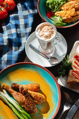Fried chicken legs with green onions and spices on the table in a beautiful arrangement