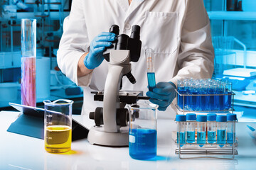 Chemical researcher working in research lab with material and microscope. biomedical engineer at...